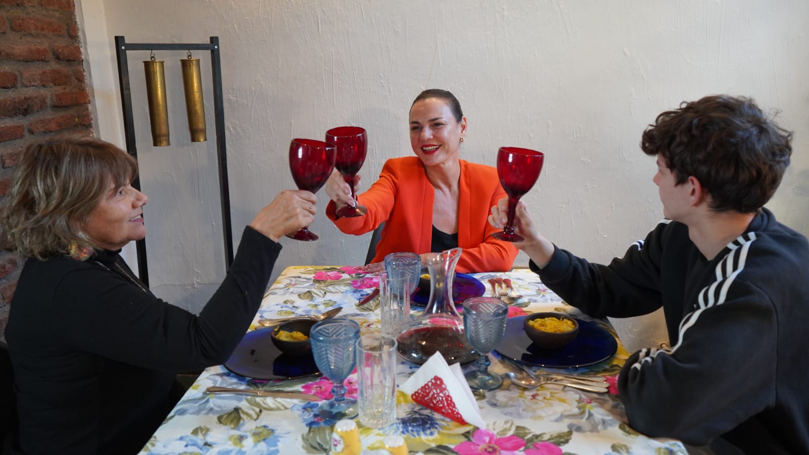Berta Lasala brindando con dos invitados alrededor de su mesa